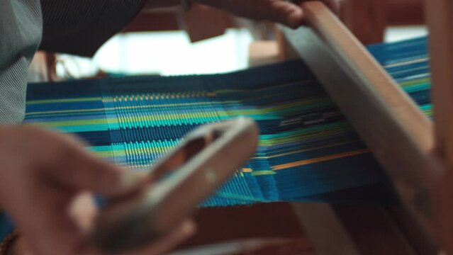 Japanese woman working traditional loom weaving.
