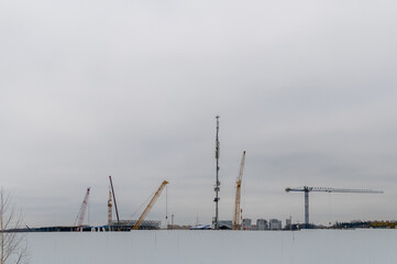 The communication tower and construction cranes are visible