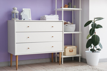 Chest of drawers with frame, towels and toys in children's room