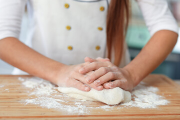 Little baker making dough in kitchen, closeup