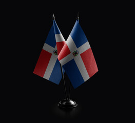 Small national flags of the Dominicana on a black background