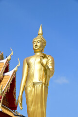 Closeup of A Golden Buddha statue stands inside a Thai Buddhist temple at Thailand.