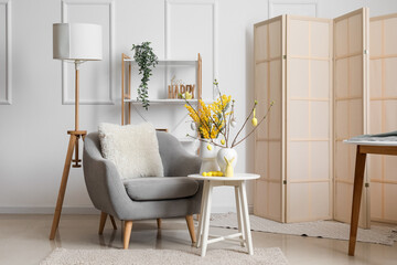 Interior of stylish living room decorated for Easter celebration with mimosa flowers
