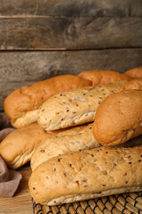 Loaves of delicious baguette on wooden table