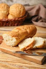 Cutting board with sliced baguette on wooden table