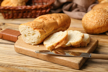 Cutting board with sliced baguette on wooden table