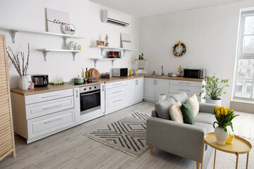 Interior of kitchen with Easter decor, white counters and sofa