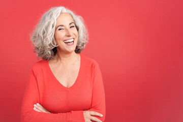 Mature woman laughing standing with arms crossed - obrazy, fototapety, plakaty