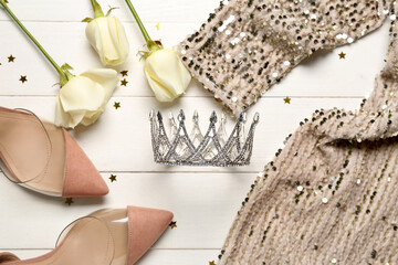 Beautiful tiara, dress, heels and roses on white wooden background. Prom concept © Pixel-Shot