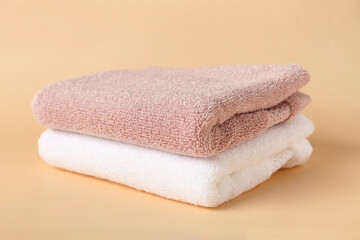 Clean folded towels on color background