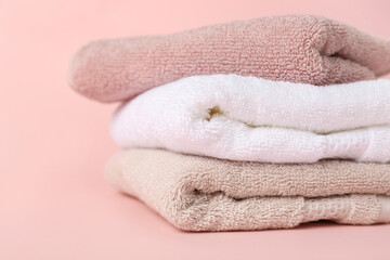 Fototapeta na wymiar Stack of clean towels on pink background, closeup