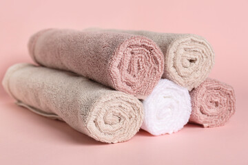 Obraz na płótnie Canvas Rolled clean towels on pink background