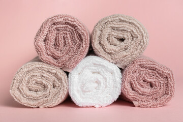 Obraz na płótnie Canvas Rolled clean towels on pink background