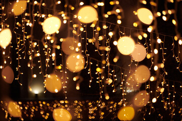 Yellow lights bokeh from christmas holiday garlands, blurred festive background, abstract outdoor...