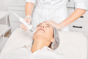 Beautician makes cryotherapy for rejuvenation woman face, anti aging cosmetic procedure with in...