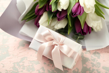 Gift box and bouquet of beautiful tulip flowers on grunge background. Hello spring