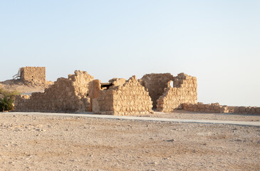 The remains  of internal buildings in the rays of the rising sun in the ruins of the fortress of...