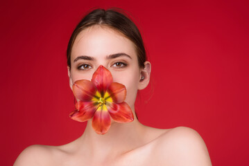 Obraz na płótnie Canvas Valentines Day. Beauty girl with tulip in mouth. Beautiful sensual woman hold tulips, studio portrait on red background.