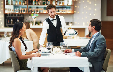 Happy couple, restaurant server and fine dining food for valentines day date, love or romance in night. Man, woman and waiter with service, party and hospitality for dinner, bonding and celebration