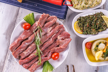 Raw beef steak with spices and tomato wood background, on plate