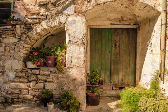 Fototapeta The architecture of the old town, the ancient Cypriot stone village, its streets with flowers and wooden doors. Selective focus