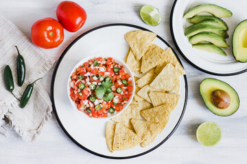 Homemade spicy pico de gallo sauce in a bowl and nachos chips on table in Mexico Latin America
