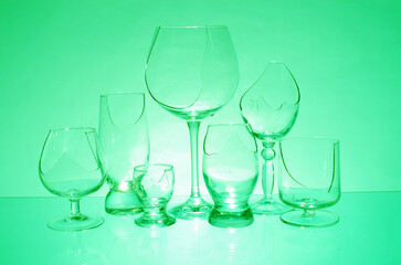 Transparent broken glasses on a green background.