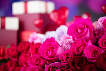 Valentines day theme. Gifts in boxes and big bouquet of natural roses on blue bokeh background.