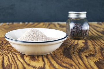 Black salt Kala namak in a glass salt shaker and on a plate on a wooden table