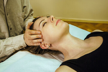 a CST treatment session for a woman, Osteopathic Manipulation and CranioSacral Therapy,  head...