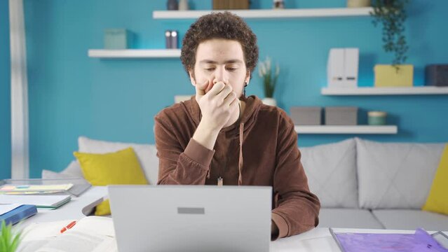 Young Uni Student Is Bored, Confused And Depressed By Studying At Home. Depressed Male Student Studying At Home, Confused, Unable To Focus On Lessons, Gets Frustrated, Gets Bad News.
