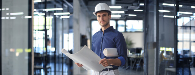 Shot of male architect wearing hardhat and inspecting new building. - obrazy, fototapety, plakaty