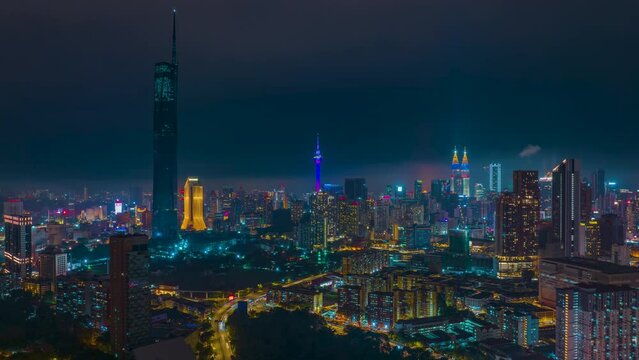 4K aerial hyperlapse of Kuala Lumpur cityscape at night overlooking Genting Highland. KL Tower lights up flag of Federal Territory Day