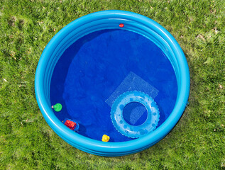 The round inflatable pool in the summer garden, top view