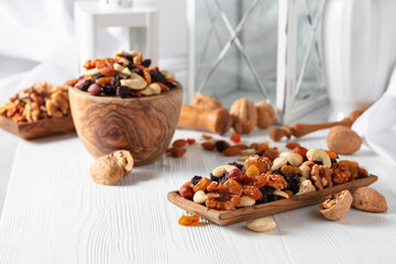 Obraz na płótnie Canvas Mix of nuts and raisins on a white wooden table.