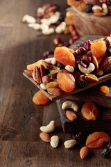 Mix of nuts and dried fruits on an old wooden table.