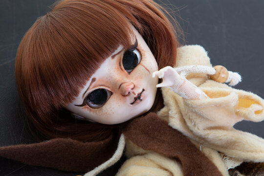 game doll scary toy plastic with tears sit on black floor background