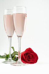 two glasses of champagne and a red rose