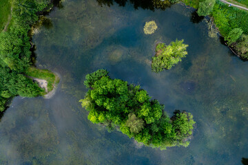 summer view from the drone on lonely island standing on the calm water of the lake