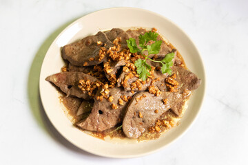 Fried pork liver with garlic on white plate. 