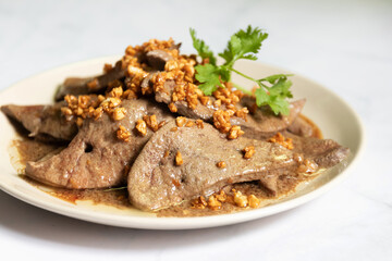 Fried pork liver with garlic on white plate. 