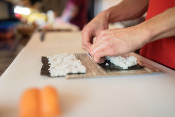 Juicy salmon sushi rolls ready to be served. Great for restaurant, food and seafood imagery. Sushi bar scene featuring salmon rolls being prepared. Perfect for food and dining out photography