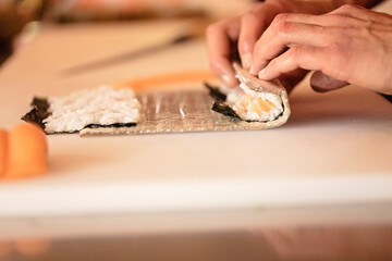 A sushi chef expertly prepares salmon, avocado rolls. Ideal for food, cooking, and culinary. Salmon rolls with side of soy sauce and wasabi on a beautiful plate. Ideal for food restaurant photography