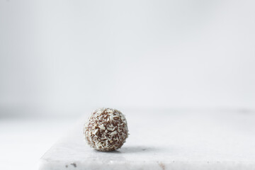 Coconut and chocolate truffles on marble tray, homemade chocolate bonbons on white background,...