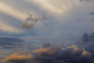 Naklejka na ściany i meble cloud against thunderstorm sky at sunset, illuminated by the sun's rays