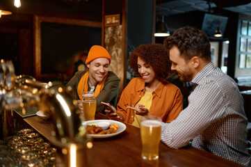 Friends watching football game online video on smartphone rest in sports bar