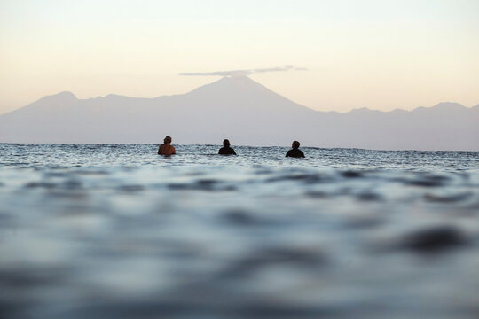 Surfers on surfboard on the sea waiting for a wave, Volcano Rinjani