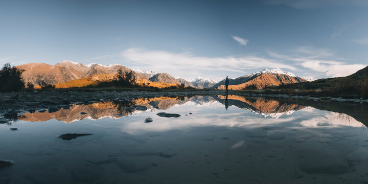Panorama of a young woman standing in front of puddle, Canterbury, NZ