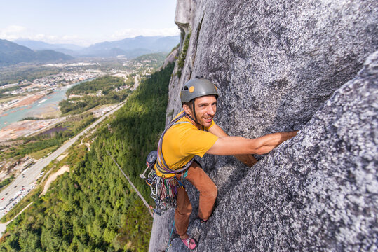 Man looking at camera while climbing multipitch on granite Squamish