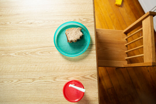 Peanut Butter Sandwich On Colorful Children's Plate With Empty Chair